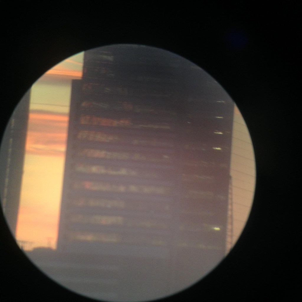 Digital image of an apartment building taken on an iPhone 6, shot through monocular.
