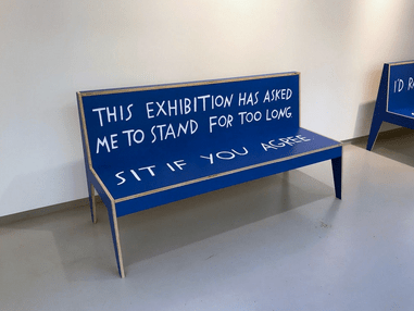 A blue bench with text written on it.